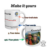 Two Camino del Norte mugs with numbered arrows showing what you can personalise: trail stats, your own words, your dates.