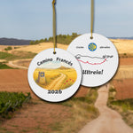 Camino Frances ceramic ornament with watercolor landscape shown front and back in front of trail landscape.