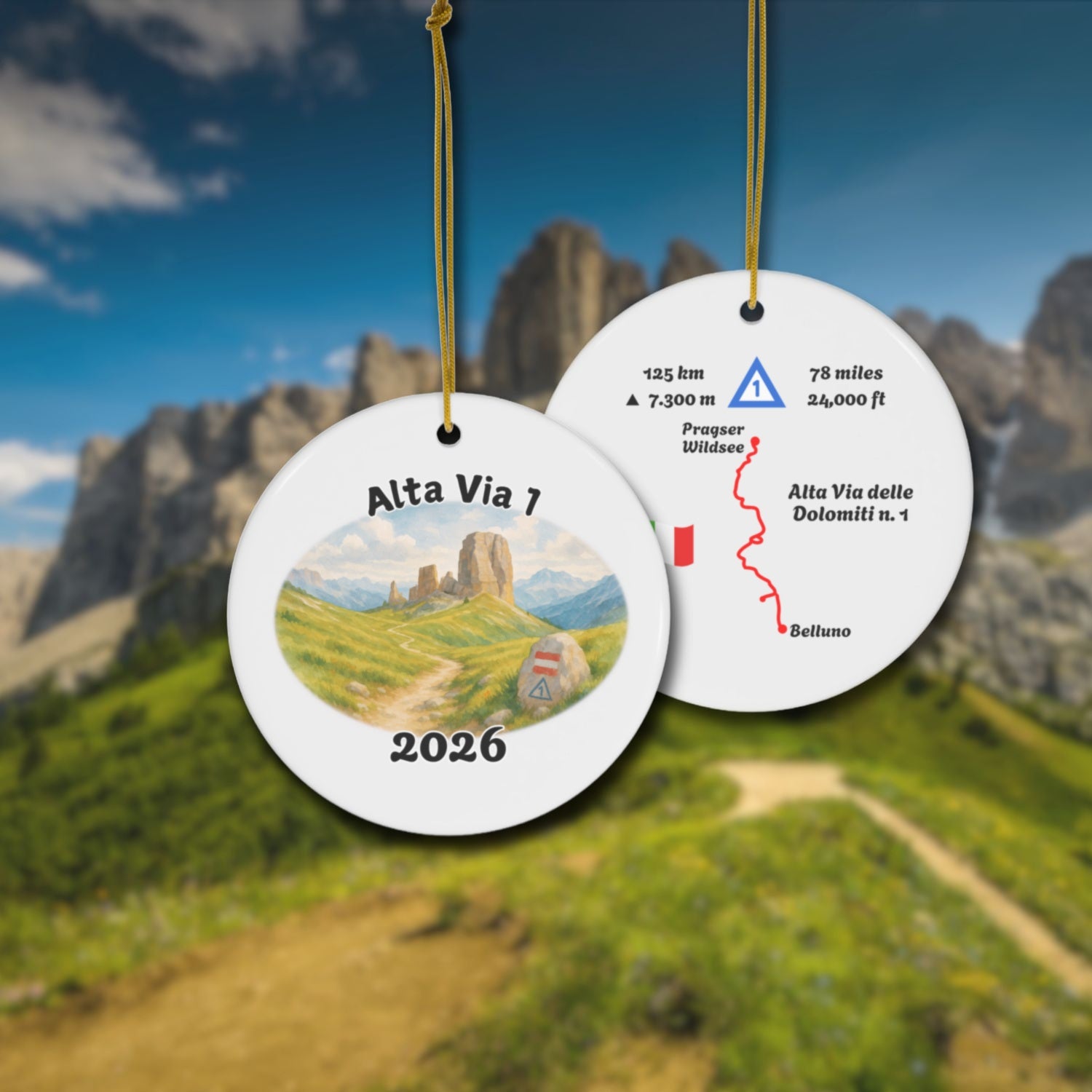 Alta Via 1 ceramic ornament with watercolor landscape shown front and back in front of trail landscape.