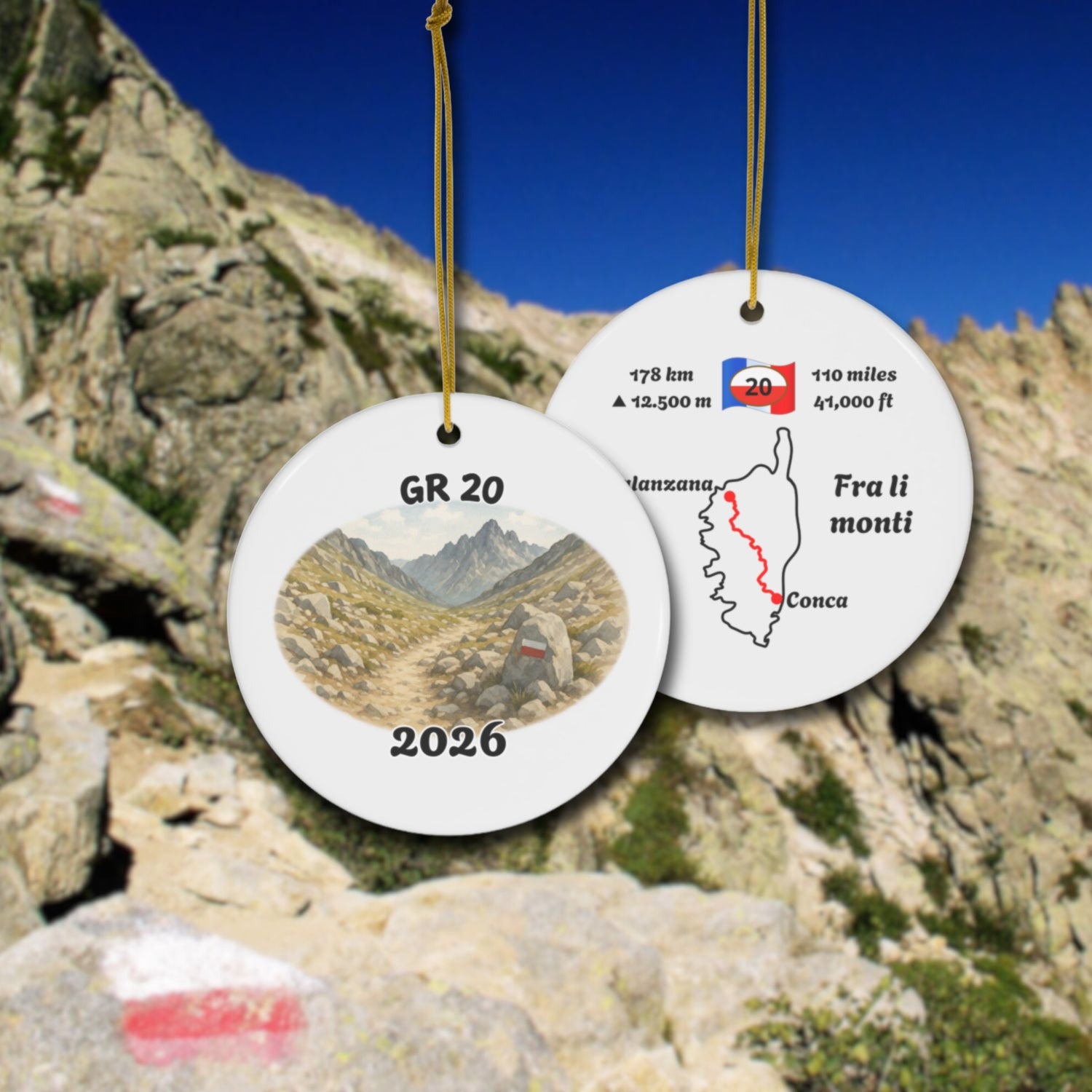 GR 20 ceramic ornament with watercolor landscape shown front and back in front of trail landscape.