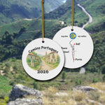 Camino Portugues ceramic ornament with watercolor landscape shown front and back in front of trail landscape.