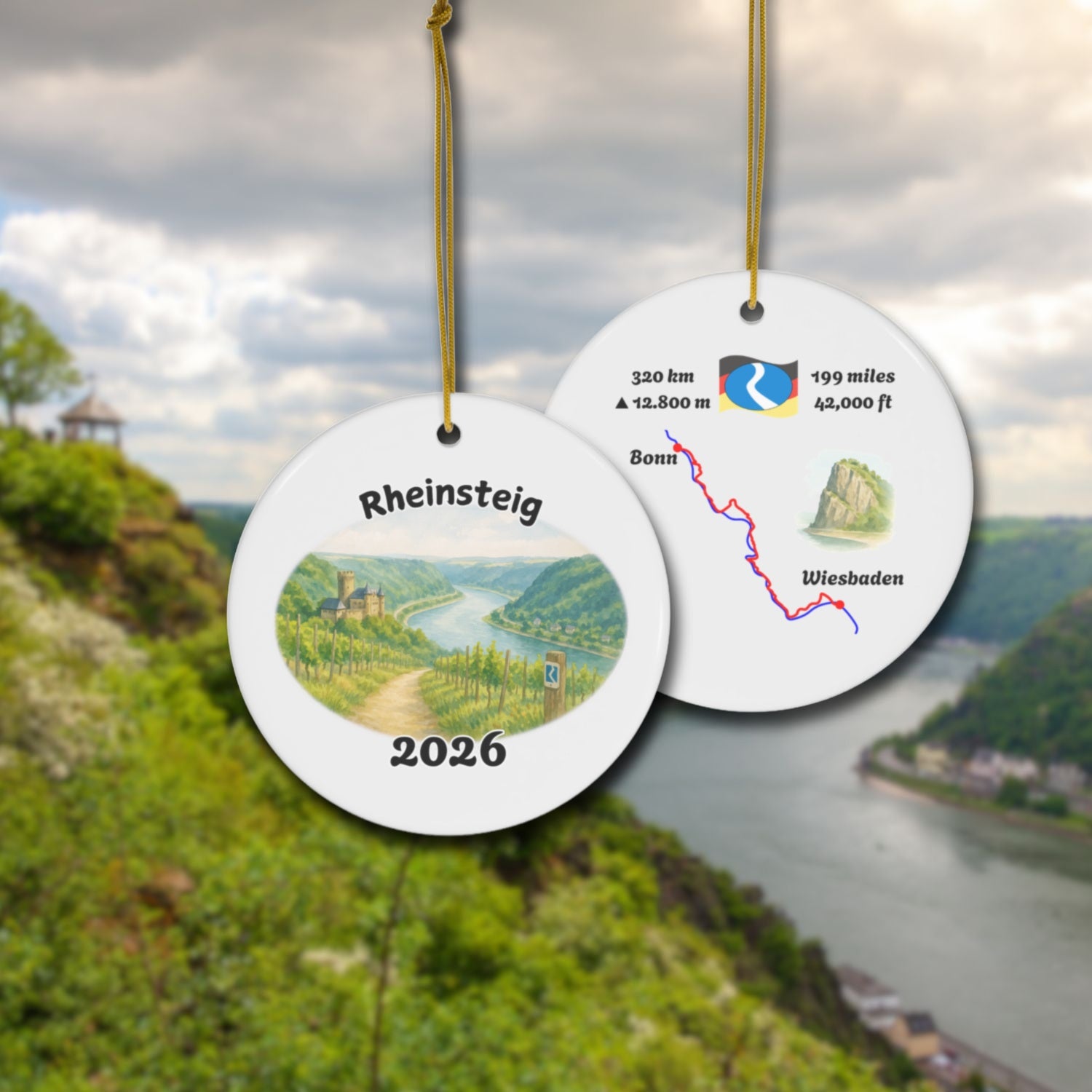 Rheinsteig ceramic ornament with watercolor landscape shown front and back in front of trail landscape.