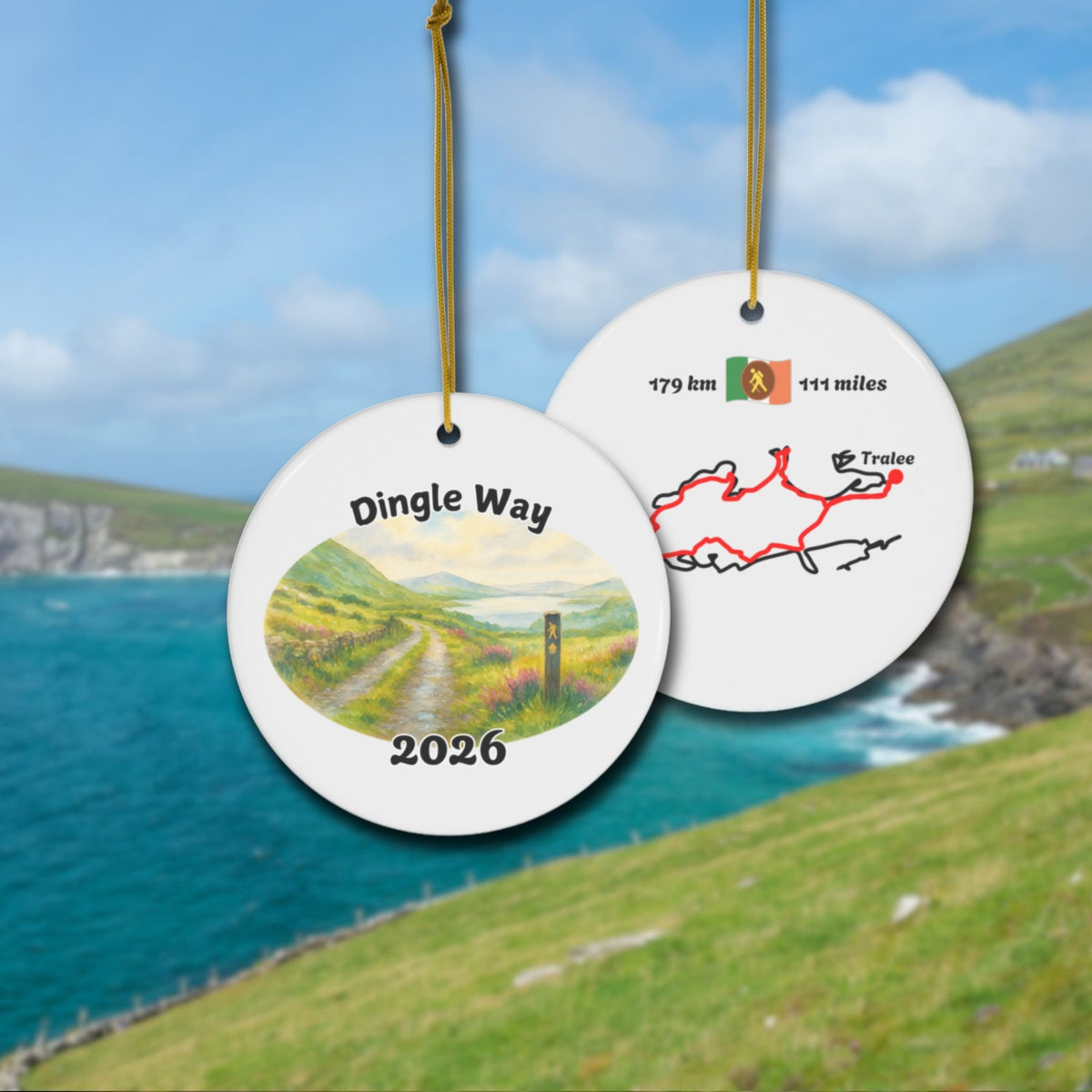 The Dingle Way ceramic ornament with watercolor landscape shown front and back in front of trail landscape.