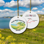 South West Coast Path ceramic ornament with watercolor landscape shown front and back in front of trail landscape.