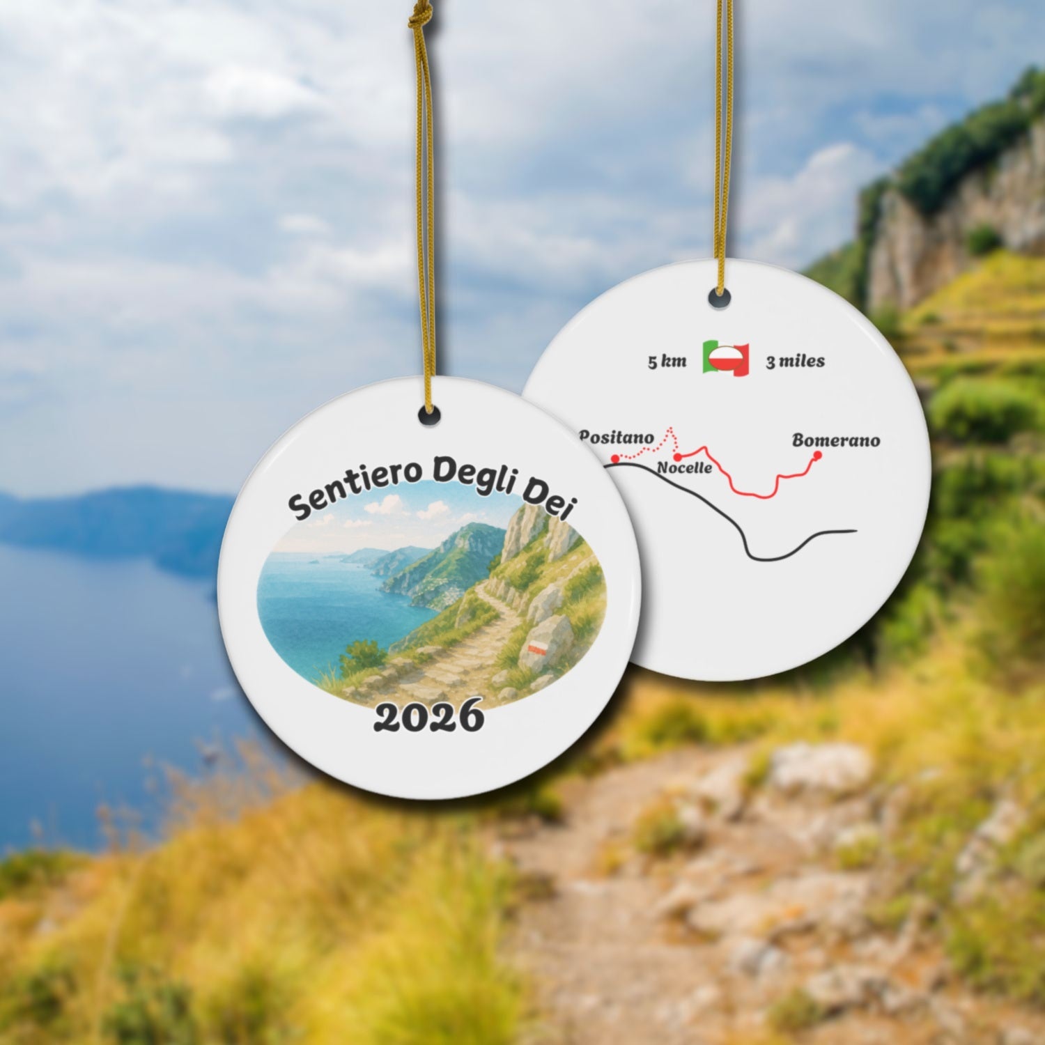 Sentiero degli Dei ceramic ornament with watercolor landscape shown front and back in front of trail landscape.